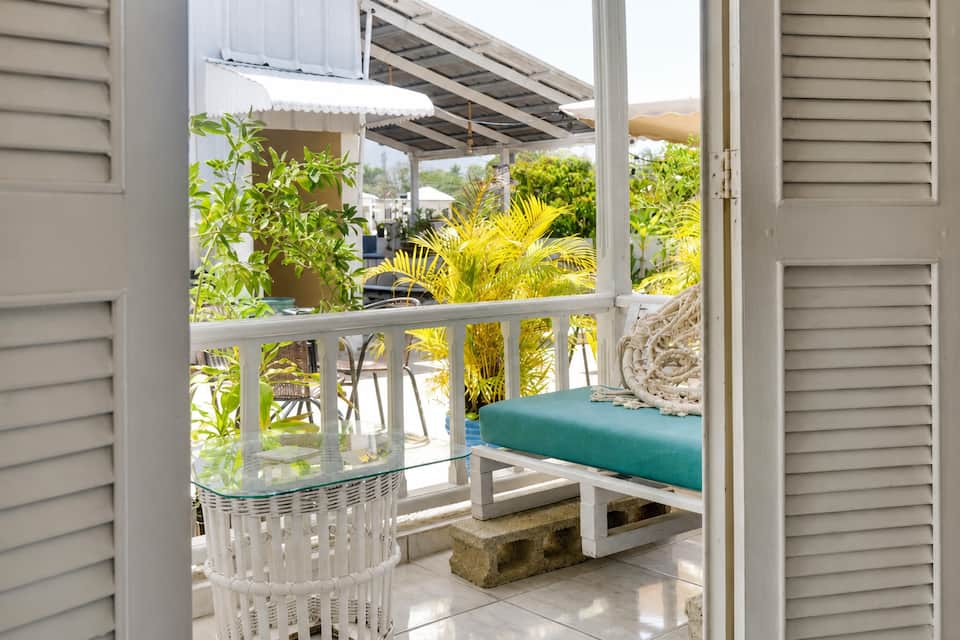 Terraza del apartamento 302 con plantas y asiento turquesa